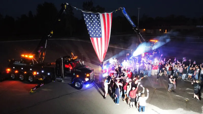 People gathered beneath the flag at the America 250 event